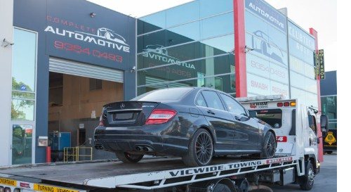 Vehicle being loaded onto a tow truck at Complete Automotive
